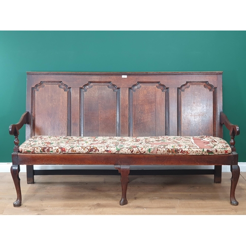 482 - An 18th Century oak Settle with four fielded panels to the back, with squab cushion and raised on th... 