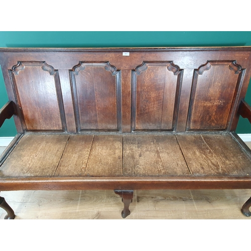 482 - An 18th Century oak Settle with four fielded panels to the back, with squab cushion and raised on th... 