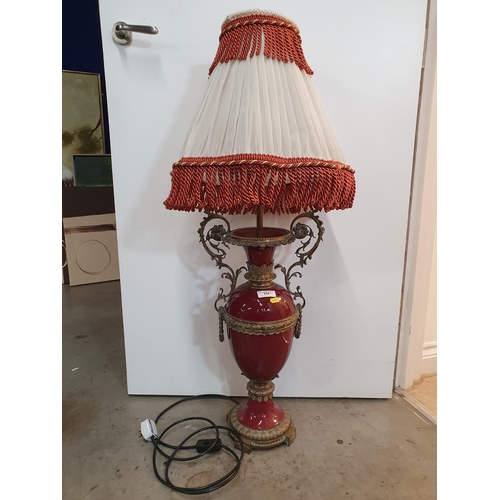 484 - A large red glazed Table Lamp and Shade with elaborate scrolled brass handles, 40in H, passed PAT