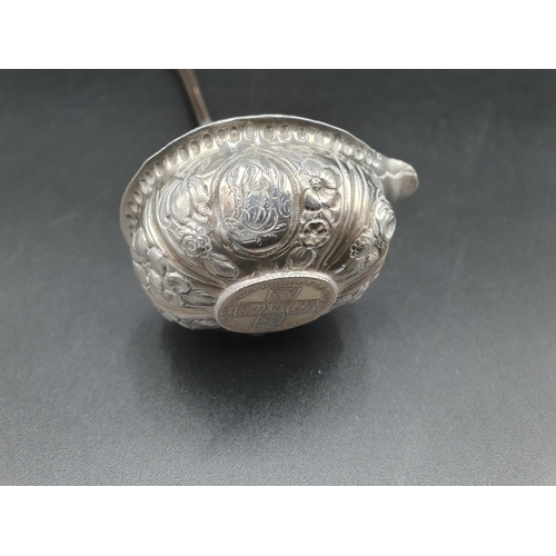 116 - A Georgian Toddy Ladle with floral embossing and coin inset Bowl, spiral whalebone handle