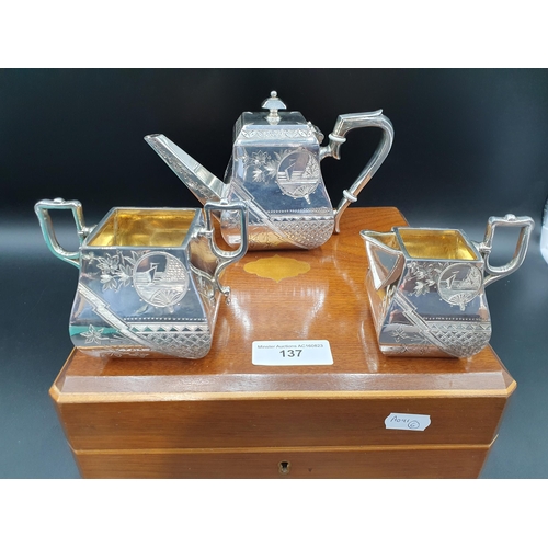 137 - A Victoria white metal three piece Aesthetic movement Tea Set, in original fitted wooden case, with ... 