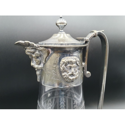 141 - A plated mounted Claret jug with harebell friezes, mask spout and knop finial