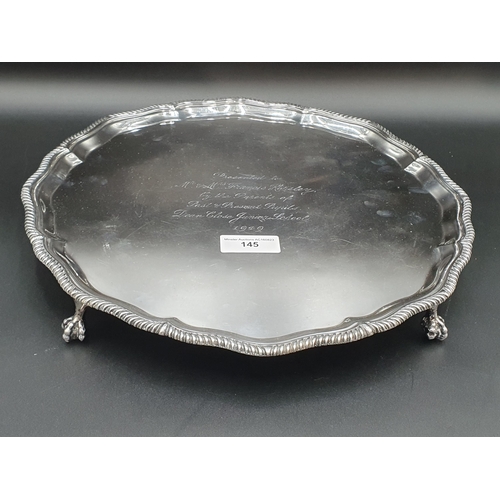 145 - A George V large silver circular Salver with presentation inscription, gadroon rim on four ball and ... 