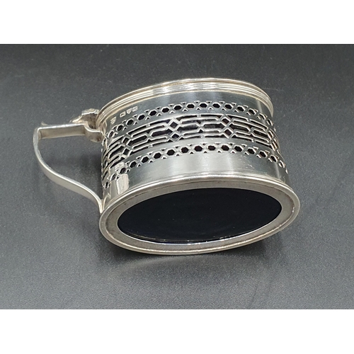 147 - A George V silver pierced oval Mustard Pot with urn final & blue glass liner. Chester 1915