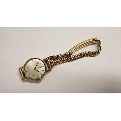 152 - A lady's Omega Wristwatch the slivered dial with hourly baton markers in 9ct gold case on 9ct gold c... 