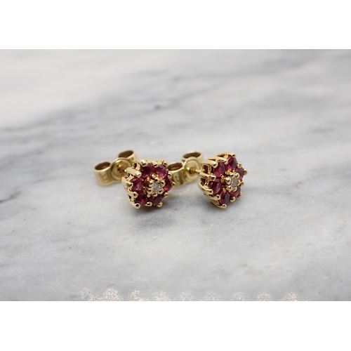 162 - A pair of Diamond and Ruby Cluster Ear Studs each claw-set eight-cut diamond within a frame of six r... 