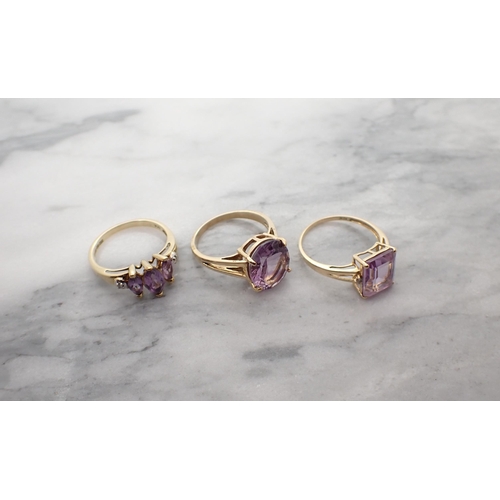 167 - An Amethyst Ring set three graduated marquise-cut stones with diamond chips to shoulders in 9ct gold... 