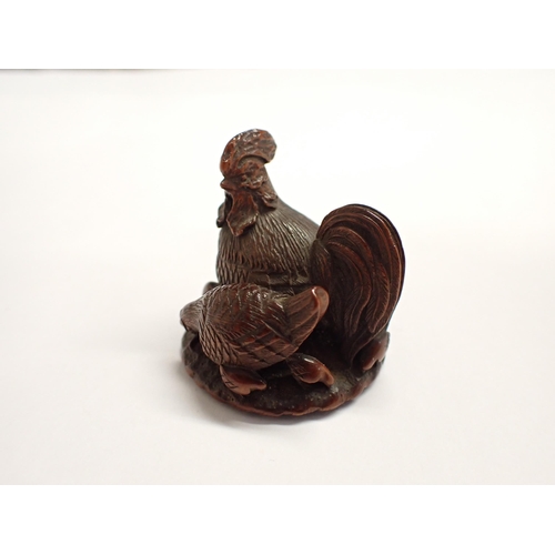 218 - A treen Netsuke formed as a cockerel and his family