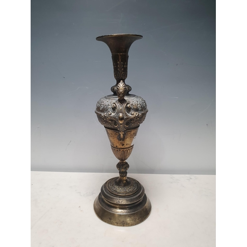 4 - A brass Vase/Urn with pair of figure heads with scrolled designs on circular pedestal base, A/F, 15