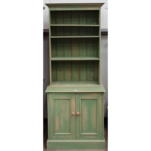 549 - A green painted Bookcase above base fitted pair of cupboard doors 6ft 6in H x 2ft 8in W