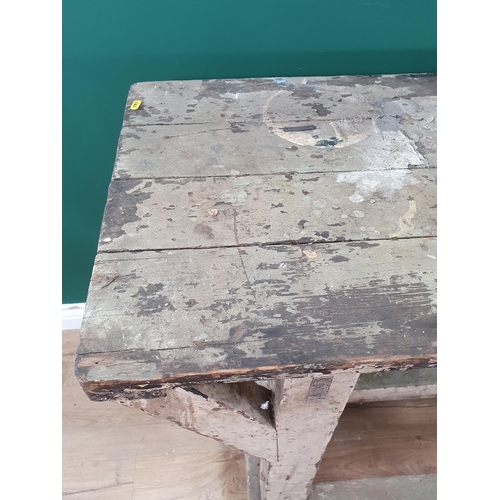 581 - A painted industrial Artists Table/Bench on square supports and stretchers and large metal castors, ... 