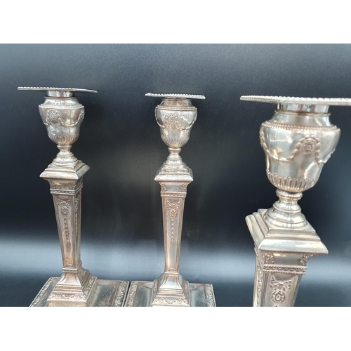 82 - A Set of four Sheffield plated Pillar Candlesticks decorated swags, ribbons and paterae on beaded sq... 