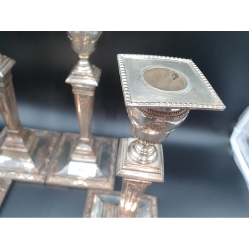 82 - A Set of four Sheffield plated Pillar Candlesticks decorated swags, ribbons and paterae on beaded sq... 