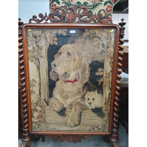 40 - A Victorian walnut framed Firescreen with needlework of a hound beneath fretwork frieze and flanked ... 