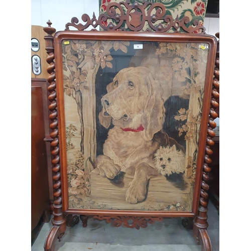 40 - A Victorian walnut framed Firescreen with needlework of a hound beneath fretwork frieze and flanked ... 