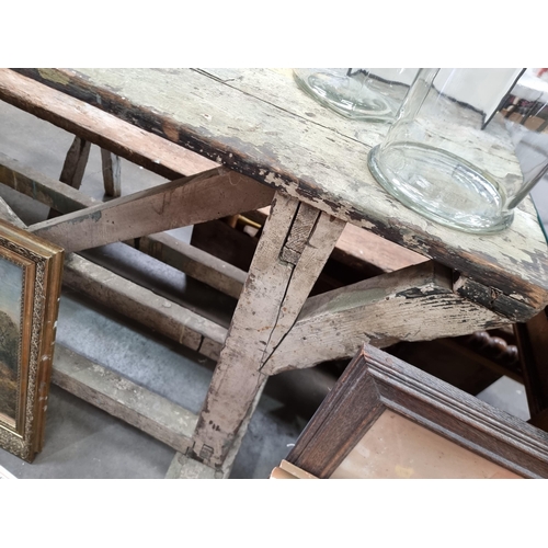 581 - A painted industrial Artists Table/Bench on square supports and stretchers and large metal castors, ... 