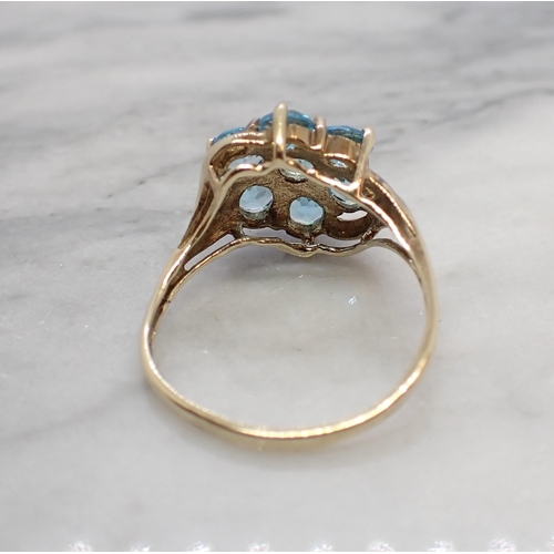 164 - A Blue Topaz Cluster Ring claw-set seven round stones in 9ct gold, ring size M 1/2