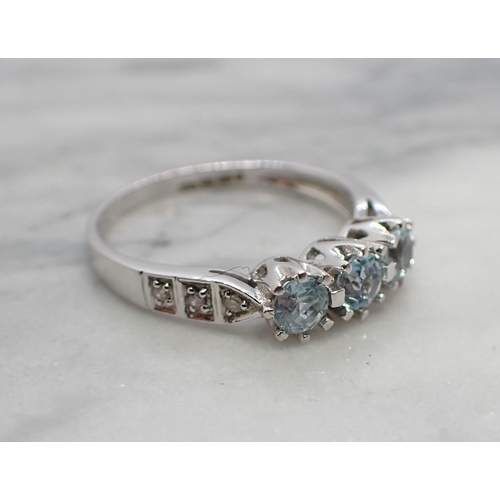 170 - An Aquamarine three stone Ring claw-set round stones with brilliant-cut diamonds pavé-set to shoulde... 