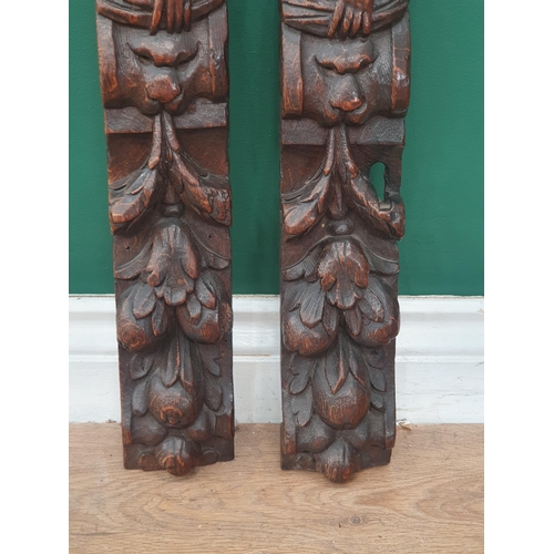 24 - A pair of 17th Century oak Caryatids with carved figures and lion masks above fruiting vines, 1ft 9