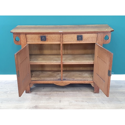 33 - An oak Arts and Crafts Sideboard with pierced spade design fitted two frieze drawers above a pair of... 