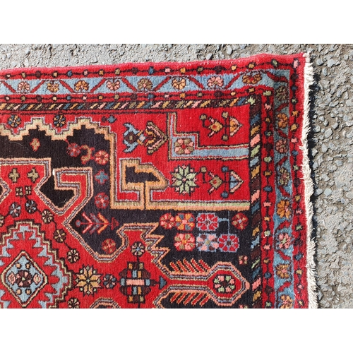 398 - A Persian Style Rug on red ground with central stylised lozenge with floral border, 4ft 11