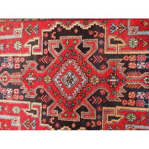 398 - A Persian Style Rug on red ground with central stylised lozenge with floral border, 4ft 11