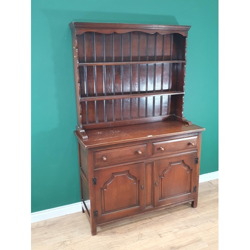 471 - A reproduction oak Dresser and Rack, the base with two fitted drawers above a pair of panelled doors... 