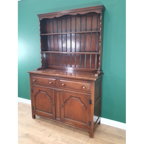 471 - A reproduction oak Dresser and Rack, the base with two fitted drawers above a pair of panelled doors... 