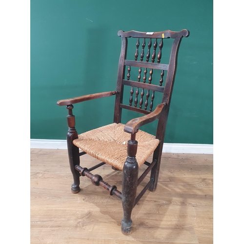 499 - A 19th Century Elm rush seated Ladderback Elbow Chair on turned supports and stretcher.