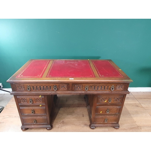 521 - A carved reproduction oak Pedestal Desk fitted eight drawers with inset writing surfaces, 2ft 7