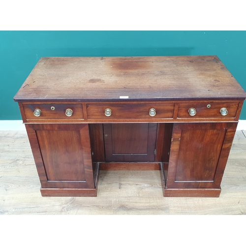 565 - A 19th Century mahogany Kneehole Desk with three drawers above three cupboard doors enclosing shelve... 