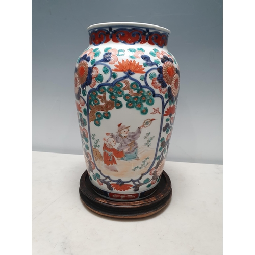 57 - A 19th Century Imari baluster Vase painted figures in shaped reserves flowering shrub surround in re... 