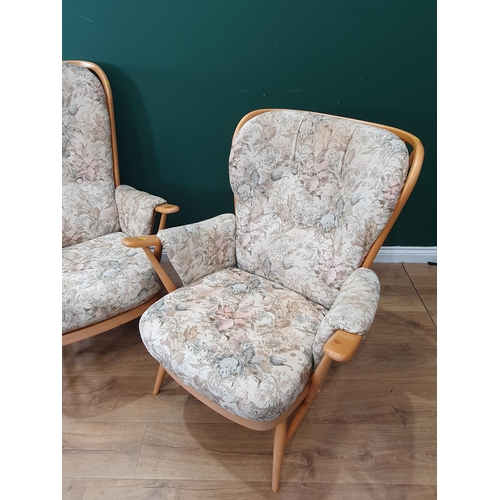 603 - A pair of Ercol Armchairs with floral upholstered cushions (Ercol Sticker Underneath). (R9).