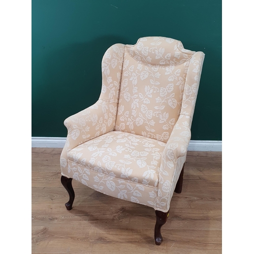 643 - A cream and floral upholstered Wingback Armchair. (R8).