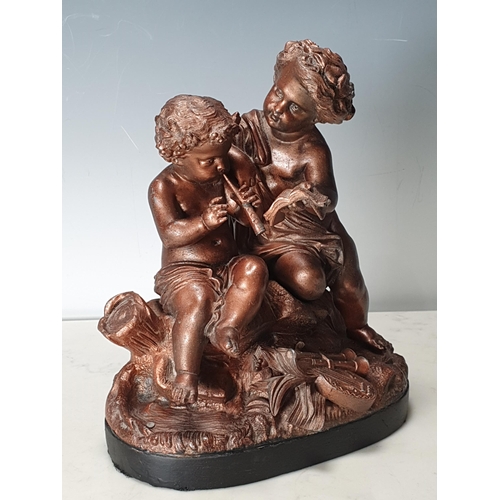 660 - A spelter Figure Group of Cherubs playing Instruments with a copper finish, raised on oval wooden ba... 