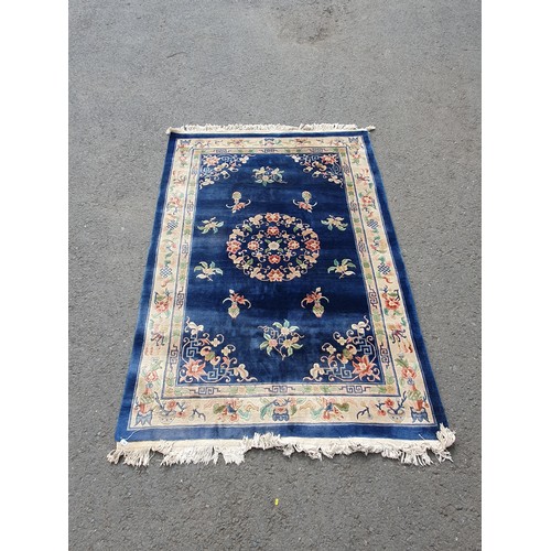 742 - A blue ground Chinese Rug with beige boarder decorated with a floral design, the central circular fl... 