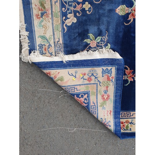 742 - A blue ground Chinese Rug with beige boarder decorated with a floral design, the central circular fl... 