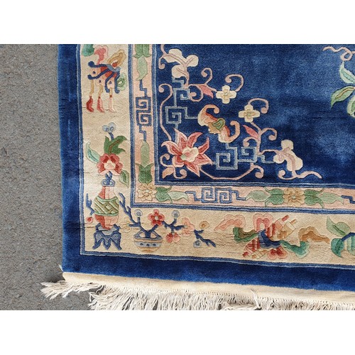 742 - A blue ground Chinese Rug with beige boarder decorated with a floral design, the central circular fl... 