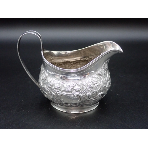 118 - A George III silver oval Milk Jug with floral and leafage scroll embossing, London 1804