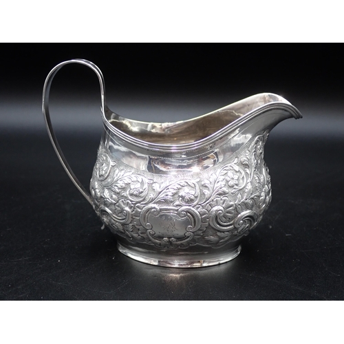 118 - A George III silver oval Milk Jug with floral and leafage scroll embossing, London 1804