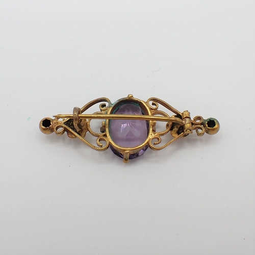 182 - A Purple Stone Brooch claw-set oval-cut stone in yellow metal mount, 4.6cms wide