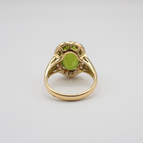 192 - A Peridot and Diamond Cluster Ring claw-set oval-cut peridot within frame of brilliant-cut diamonds,... 