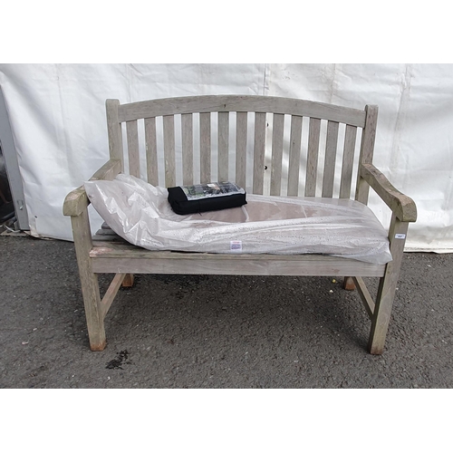 247 - A wooden Garden Bench with arched slatted back and seat with seat cushion and cover, 3ft 11in W