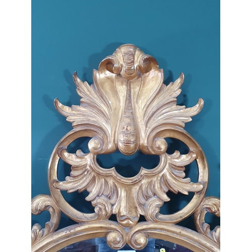 43 - A gilt painted Wall Mirror with bevelled plate with carved leafage and scrolled decorated frame, 5ft... 