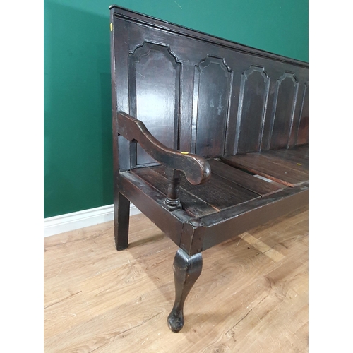 554 - An 18th Century oak Settle with fielded four panel back raised on cabriole supports and pad feet 6ft... 