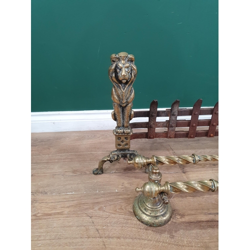 600 - A brass and iron Fender with lion finials, 3ft 5in W a pair of brass Fire Implements with spiral ste... 