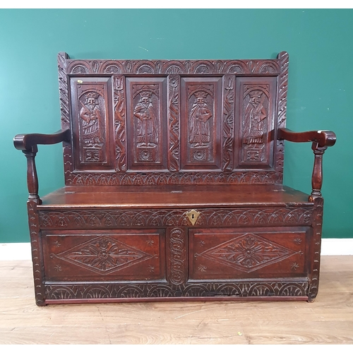 641 - A Victorian carved oak Settle with four panel back carved with warriors above box seat 4ft W x 3ft 1... 