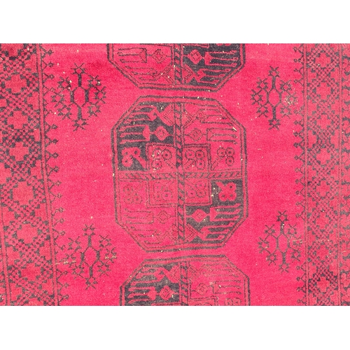 726 - A Turkoman Rug, multi-bordered with central row of medallions on a red ground, 7ft 2in x 3ft 10in