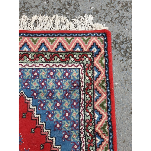 727 - A Tunisie bordered Rug with central red lozenge on a blue ground, 5ft 10in x 3ft 7in