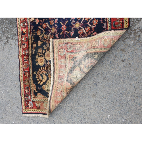 729 - A bordered Persian style Runner with floral designs on a blue ground, 10ft 7in x 3ft 10in